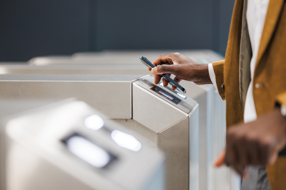 Person scanning their phone at a turnstile