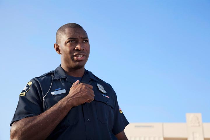 Tile|Police officer standing outside against blue sky