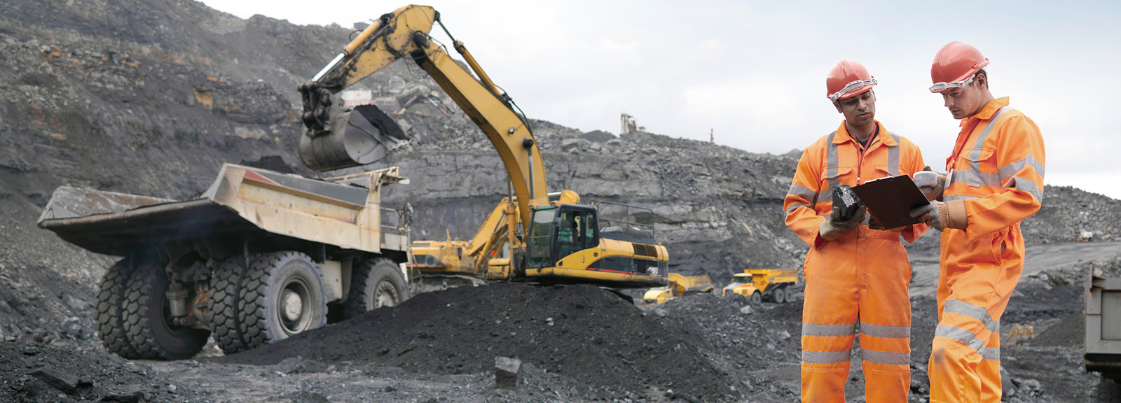 Two men at construction site with bulldozer in background