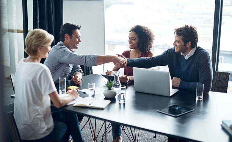 Tile|a group of people in a meeting room, two men holding hands