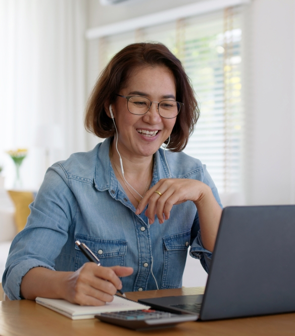 sqre|Woman using laptop writing on pad