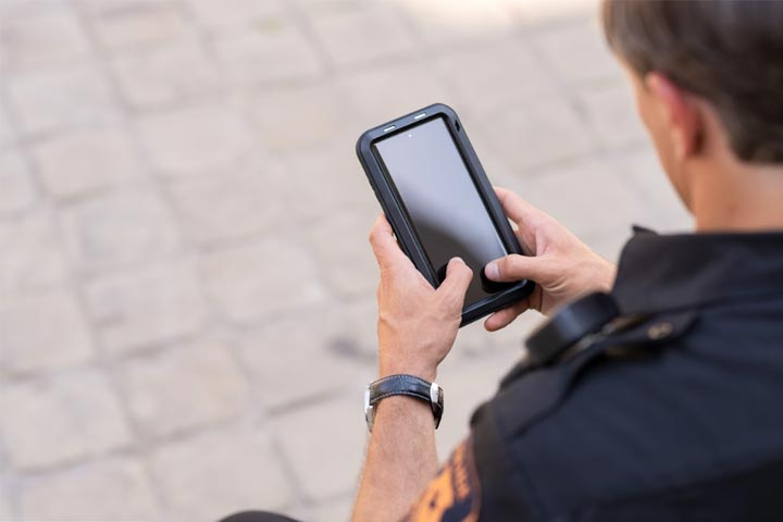 Tile|Close up of an officer looking at his phone