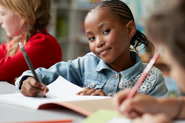 Tile|Smiling female student working at her desk