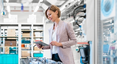 Wide|Retail store owner examines a handheld smart device in her shop