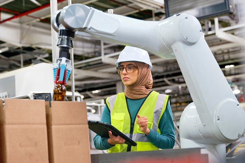tile | woman wearing helmet holding tablet controlling mechanical arm