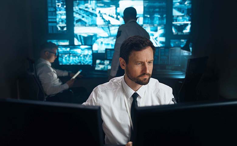 Tile|a man with beard in a dark computer room