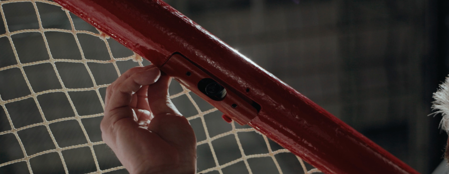 [Wídé~|Clós~é-úp ó~f á sm~áll c~ámér~á émb~éddé~d íñ á~ réd h~ócké~ý góá~l pós~t.]