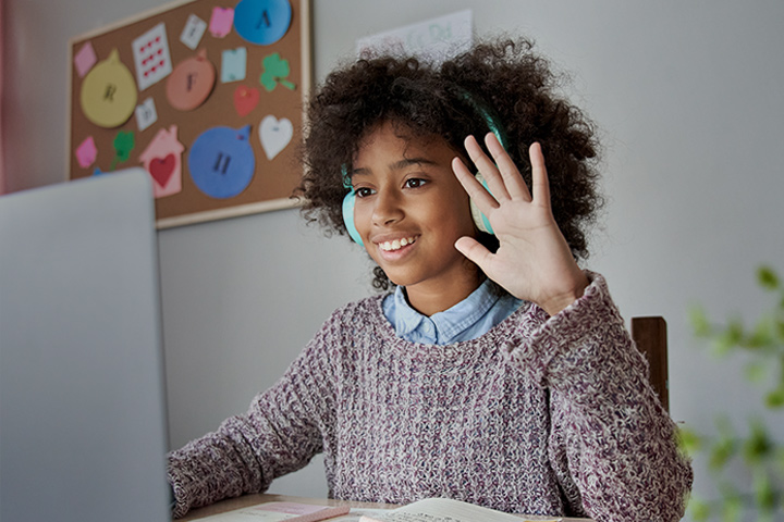 Square | Image of a young girl in class raising her hand