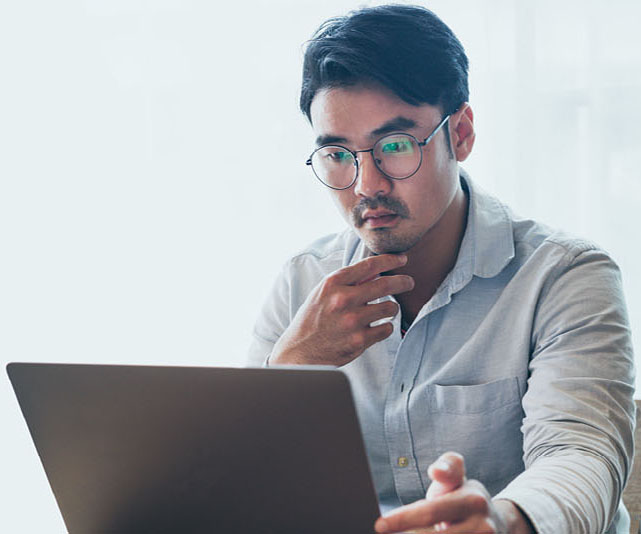 Sqre|A man with glasses look at a laptop