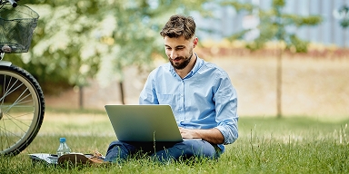 Tile| A guy sitting on ground using laptop