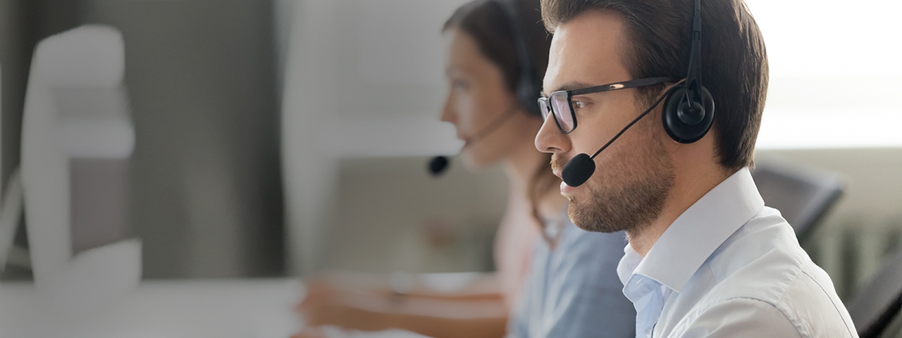 Full | Man wearing a headset talking in a call center